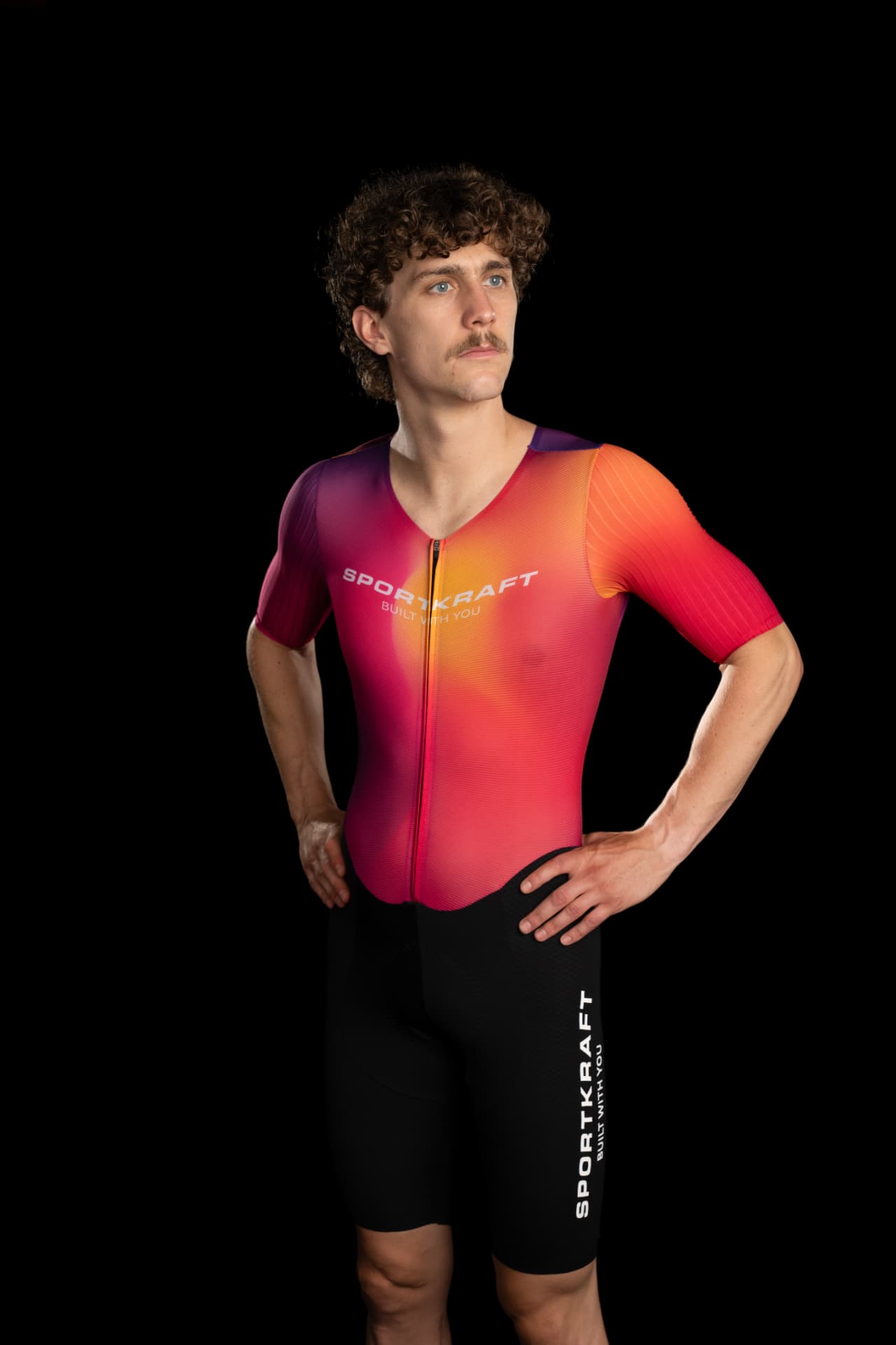 Rider in the SPORTKRAFT Race 2.3 Short Sleeve Race Suit in a pink, orange and purple gradient