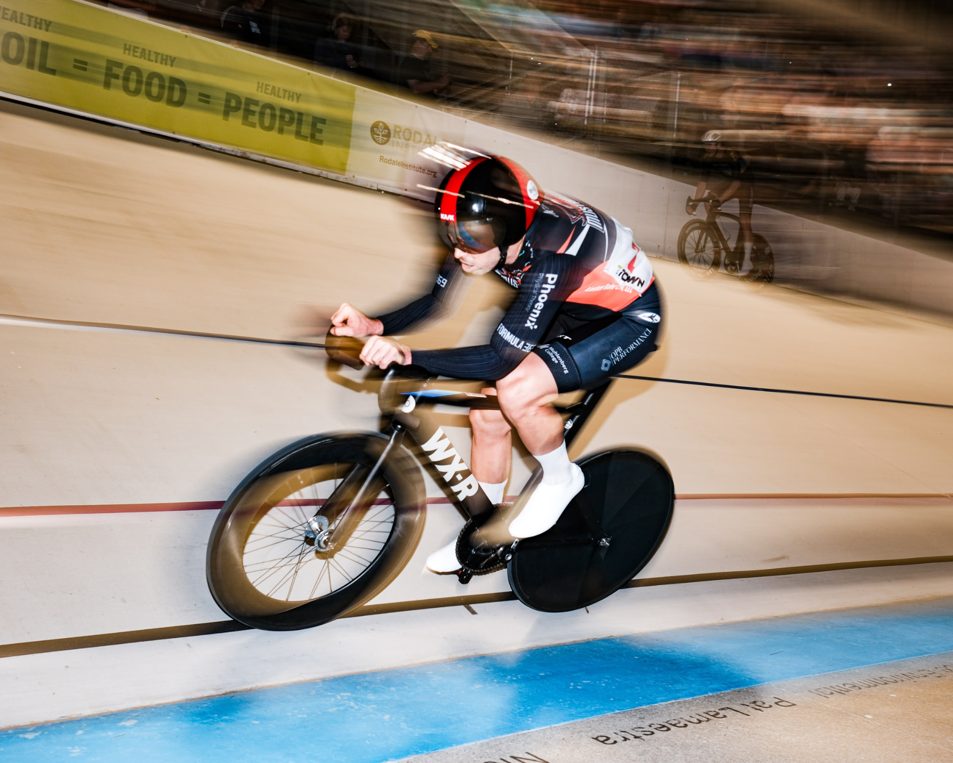 Track rider at speed in a custom Sportkraft team kit