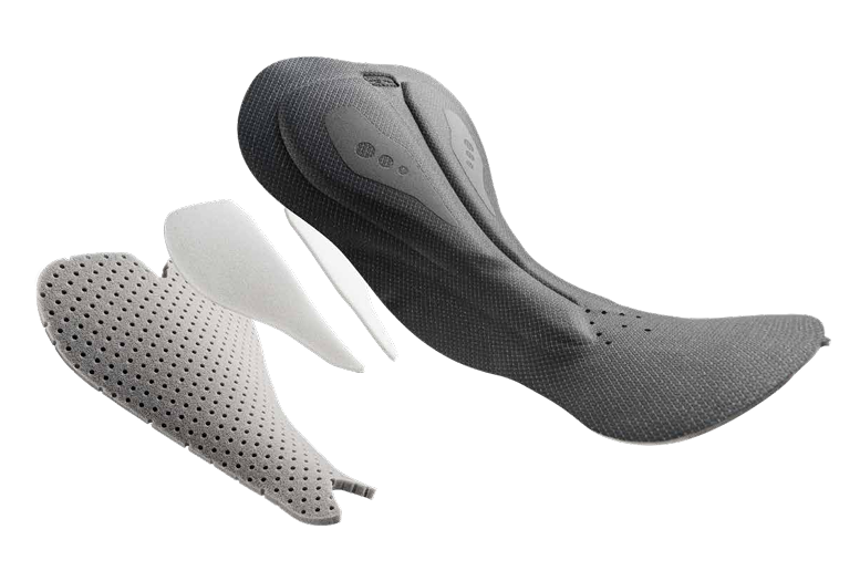 Exploded view of a multi-layer cycling chamois showing perforated foam layers and top fabric